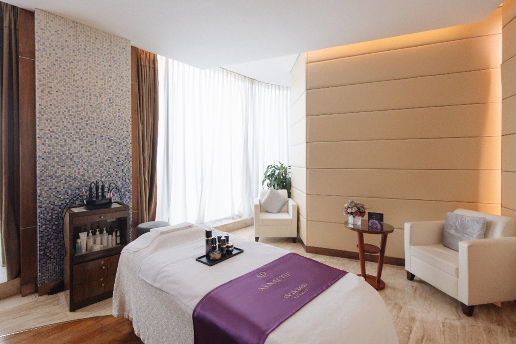 A massage room with a bed and a chairAI-generated content may be incorrect.